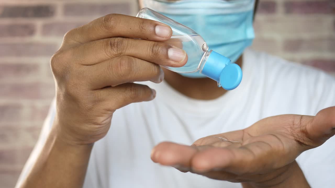 aplicación de desinfectante de manos con máscara