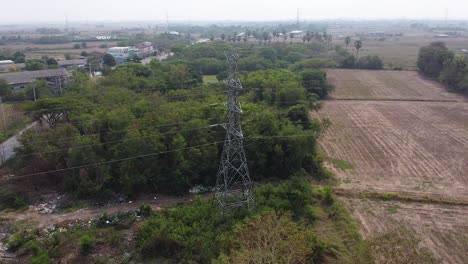 Lopburi,-Tailandia---Un-Alto-Mástil-De-Torre-Rodeado-De-Frondosos-árboles-Verdes-En-El-Campo---Toma-Aérea