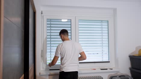 diy project: man fits a pleated shade on a bedroom window for light control and privacy