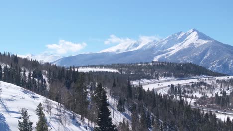 amazing winter landscape of snow capped mount swan, forest and highway in colorado