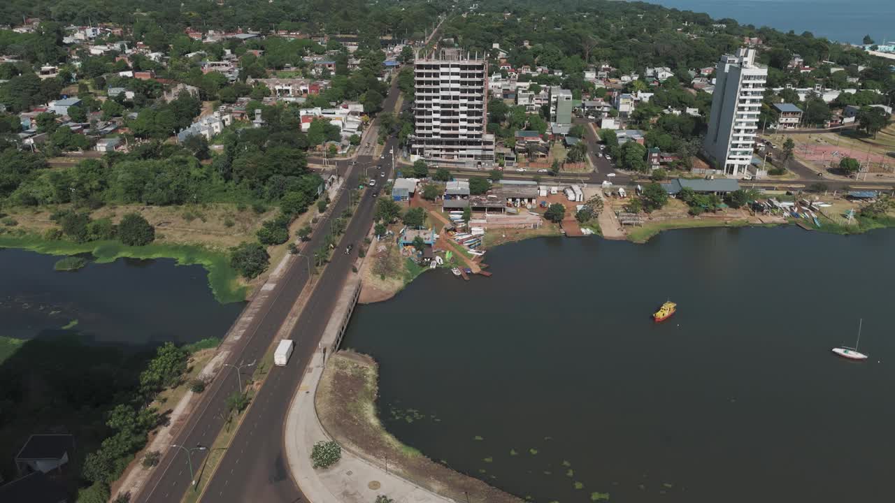 imágenes inmersivas de drones capturan la pintoresca vista aérea del río panara, con un puente bullicioso, vehículos en la carretera, edificios de construcción, árboles verdes exuberantes y casas encantadoras