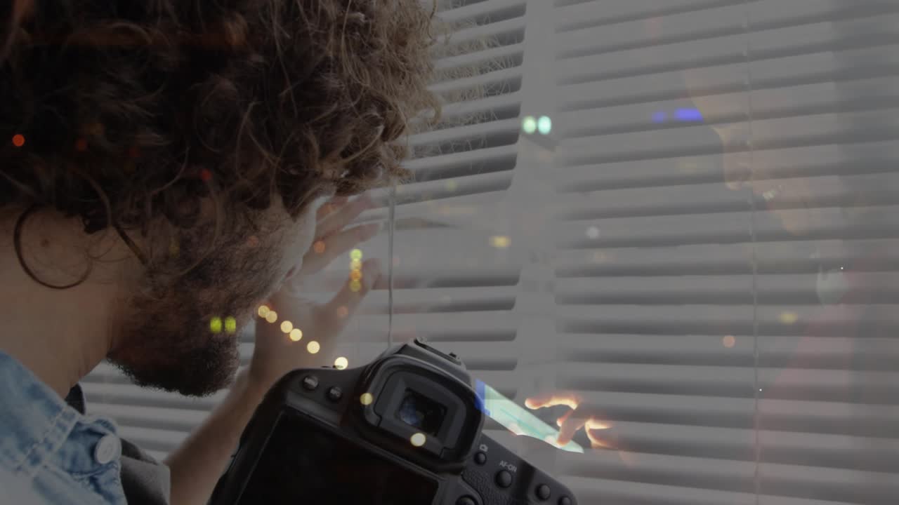 Fotograf vipper persiennerne i vinduet, der afslører byens lys, og forbereder et DSLR-foto af bybilledet.