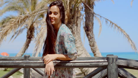 Mujer-Joven-Y-Bonita-Apoyada-En-La-Barandilla-En-La-Playa