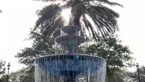 smooth, cinematic dolly around a famous and historic fountain with sunlight glinting off of the water in downtown st mary's, georgia