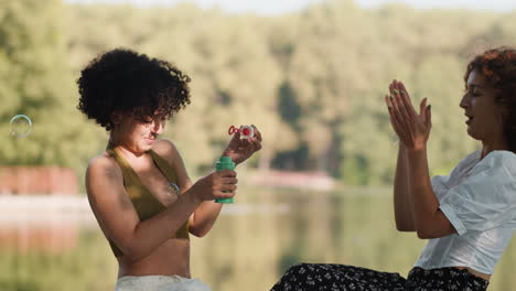 women blowing bubbles outdoors