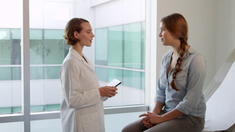 doctor meets with teenage patient in exam room shot on r3d