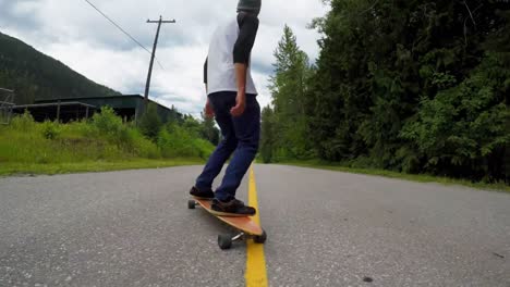 Man-skateboarding-on-the-rural-road-4k