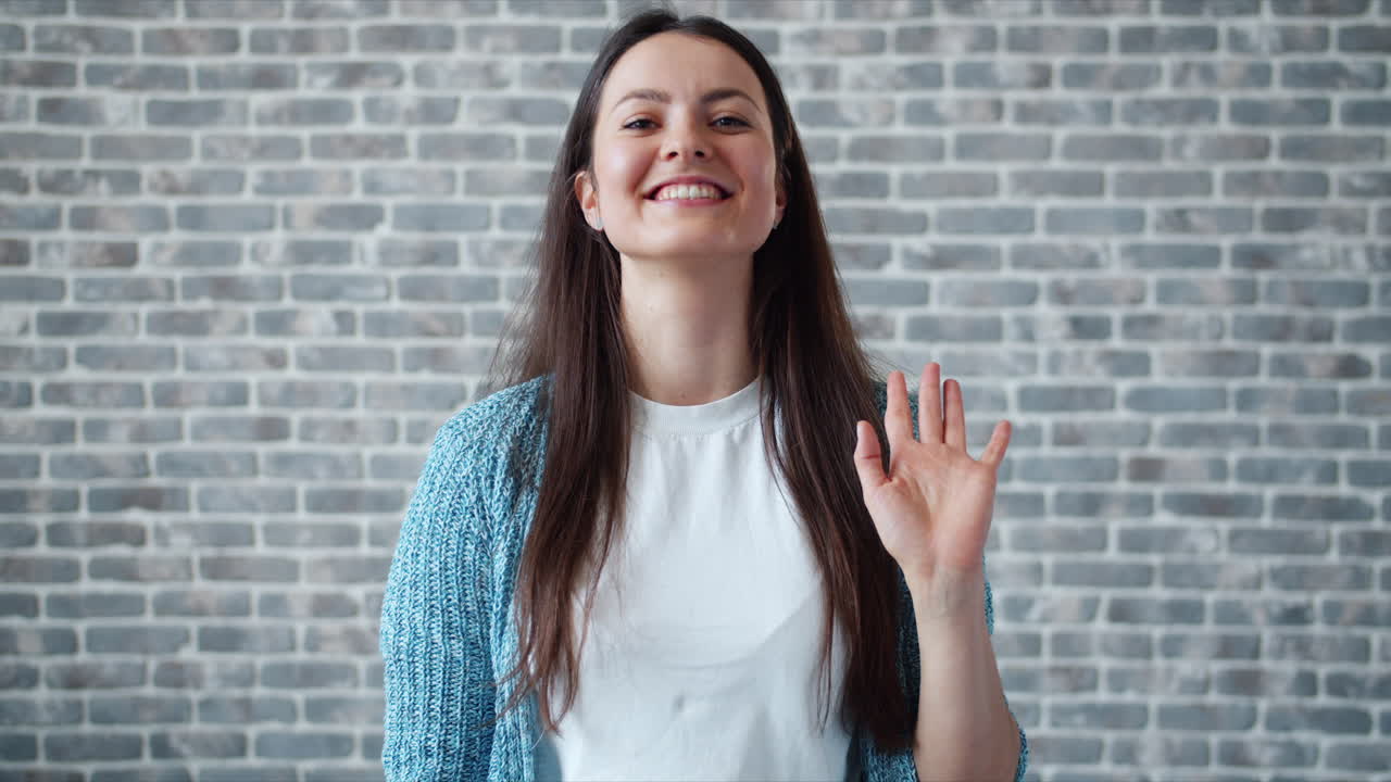una mujer saludando.