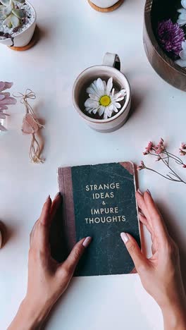 hands holding a book with strange ideas and impure thoughts