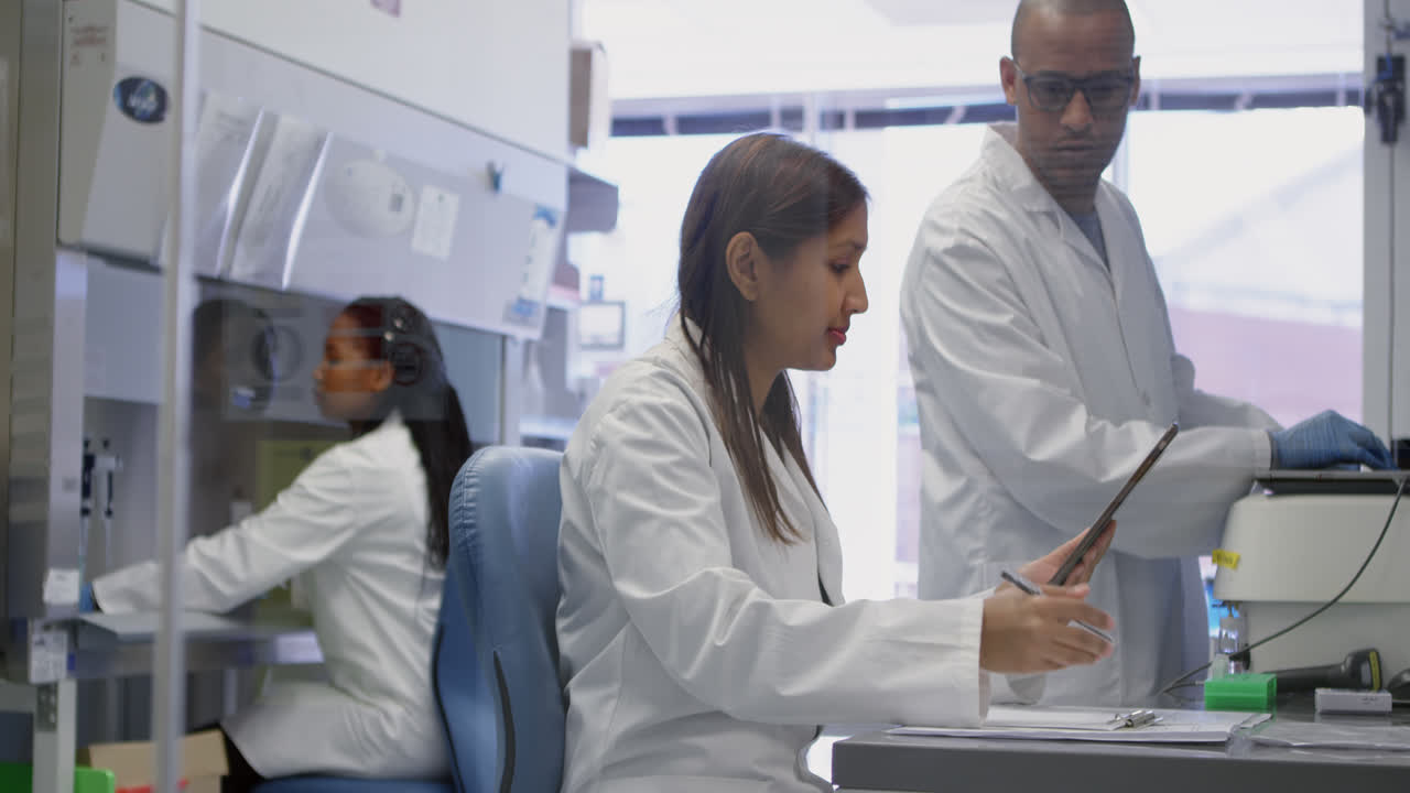 equipo de científicos discutiendo sobre una tableta digital 4k