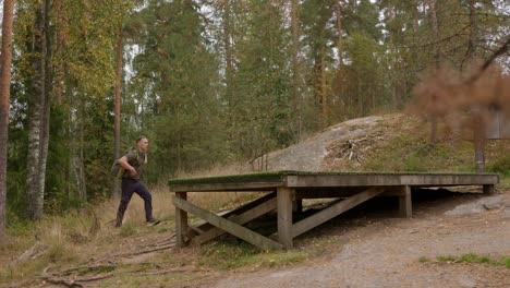 disc golfer approaches a tee in the forest and inspects course - wide shot