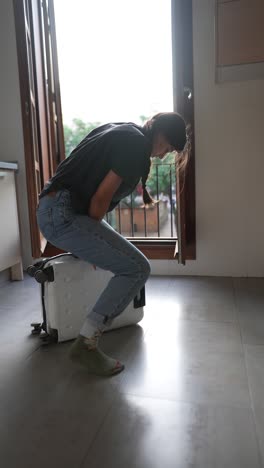 woman moving luggage in an apartment