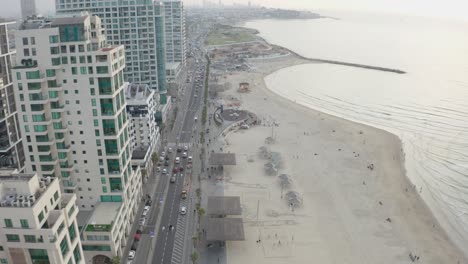 4k aerial - majestic cityscape and boardwalk - tel aviv beach during sunset