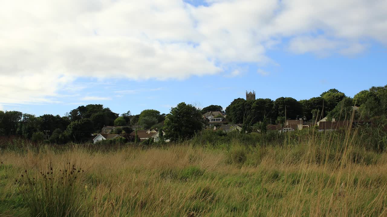 escena rural de una ciudad distante en la reserva natural de hayle bajo un cielo azul, cornualles, inglaterra