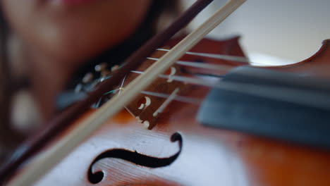foto de cerca de una mujer joven tocando el violín. una adolescente usando el arco del violín