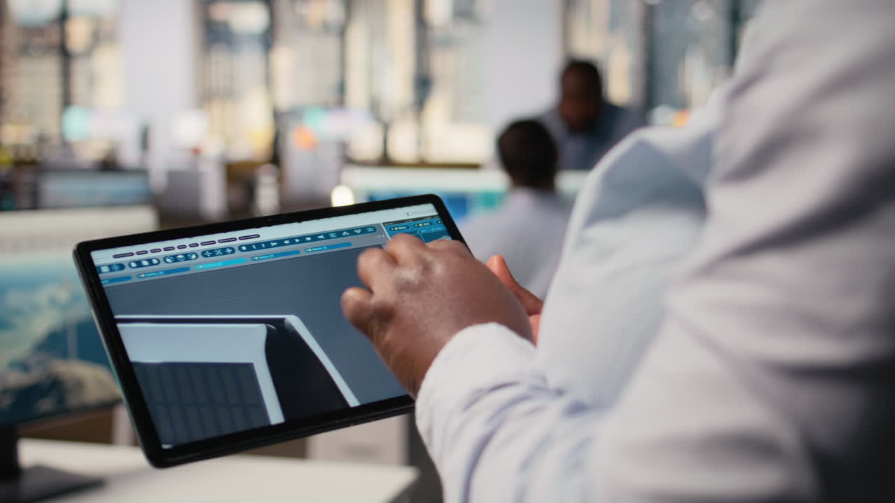 Close Up Of Technician Using Tablet To Create Solar Powered Device Design