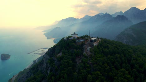 video aéreo 4k de un drone de una estación de cable de tunektepe teleferik posicionada en la cima de la colina con las montañas en el fondo