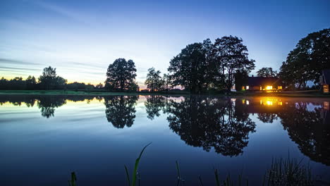 Vista-Idílica-De-Una-Casa-Lago-Con-Reflejos-De-Espejo-Durante-La-Puesta-De-Sol