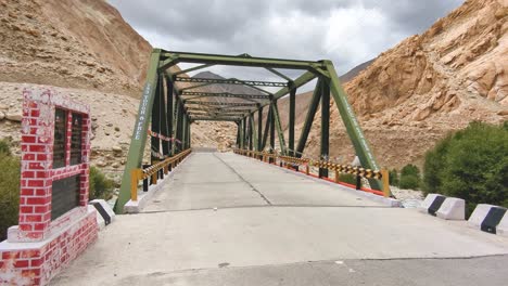 Punto-De-Vista-De-Caminar-Sobre-Un-Puente-Sobre-El-Río-Indo-Con-El-Telón-De-Fondo-Del-Alto-Himalaya-De-Leh-Ladakh-India