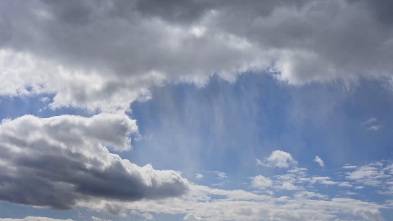 A dramatic time lapse in the sky where thick storm clouds begin to cover patches of blue. The contrasting tones highlight the transition between clear and stormy weather.