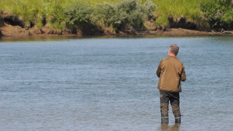 back view of senior man fishing in tornio, lapland, northern finland