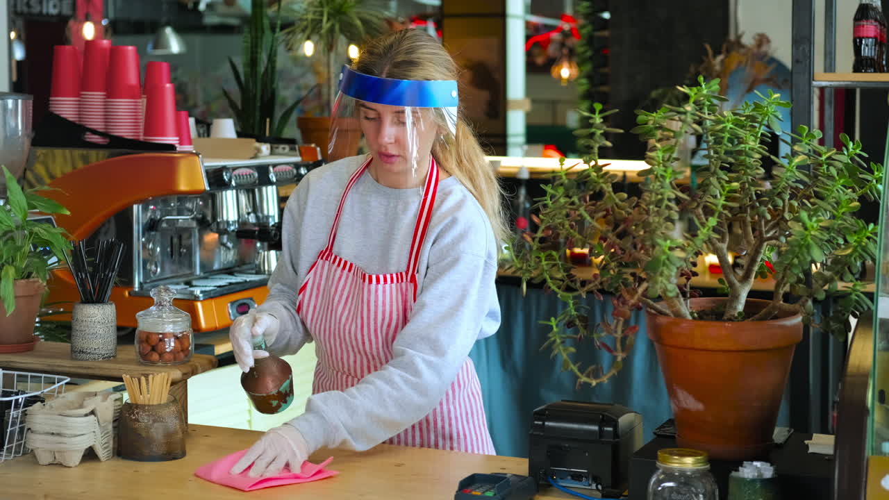 코로나19 팬데 기간 동안 바리스타가 카운터를 청소하고 있습니다.