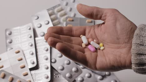 different kinds pills in men's palm.