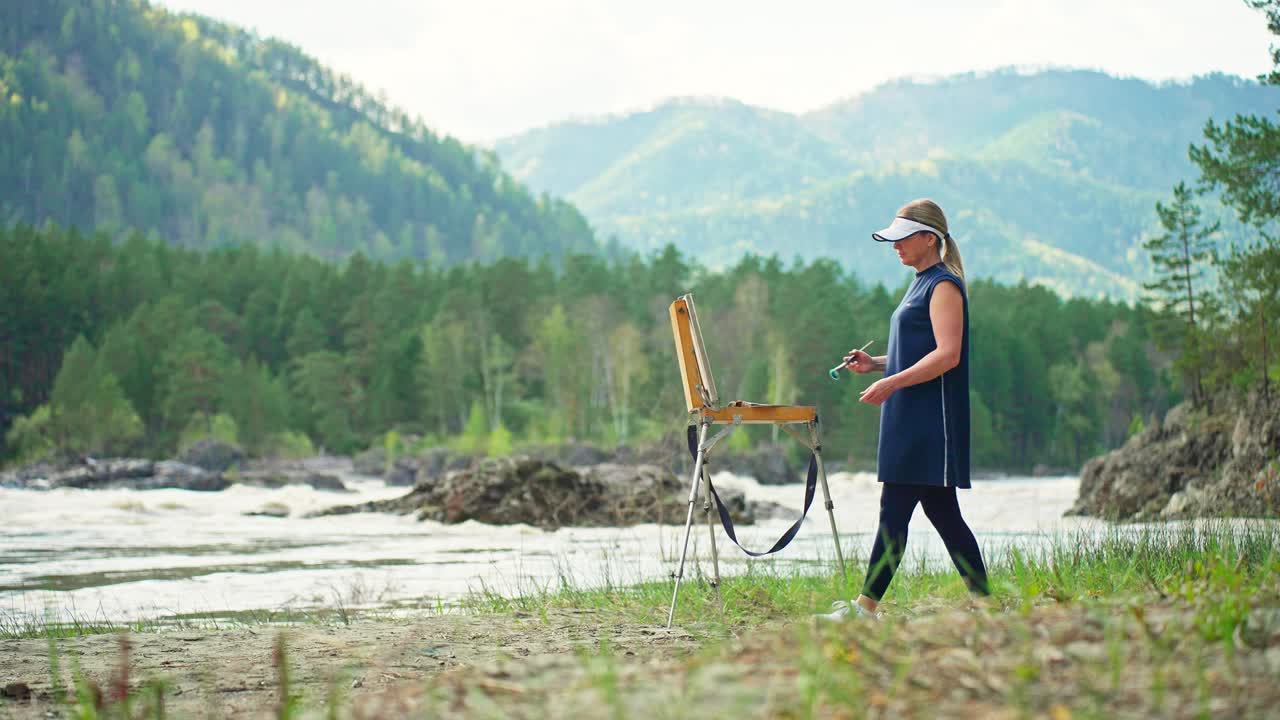 Artist painting in the mountains by the river