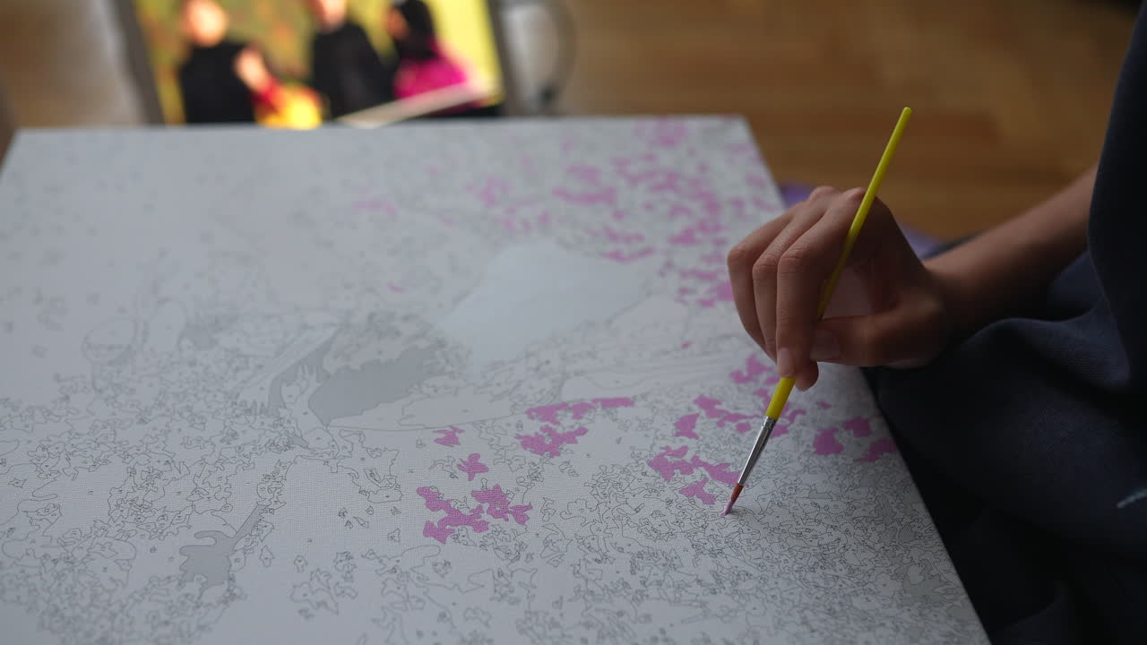 persona pintando una pintura por números