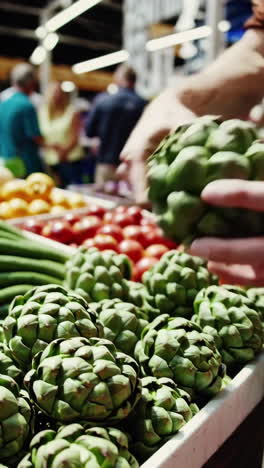 person holding an artichoke at a farmers market