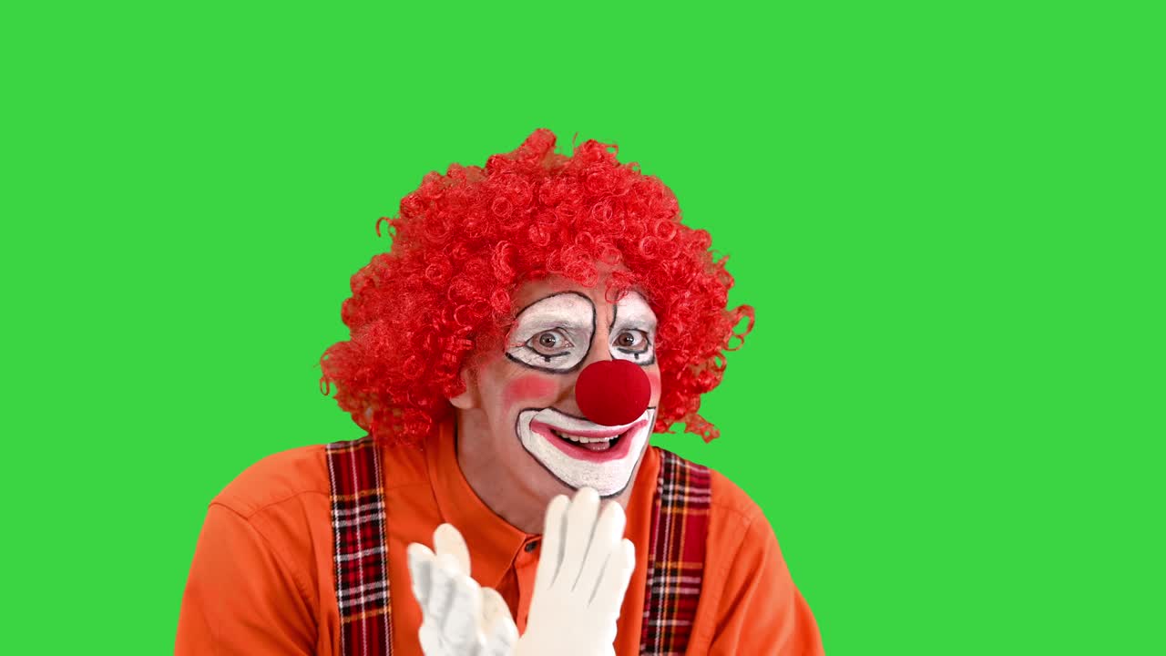 payaso gracioso teniendo un poco de pensamiento duro en una pantalla verde, clave de croma