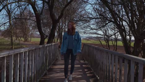 girl crossing a bridge on a sunny day