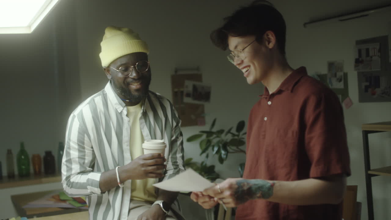 Two Men Collaborating and Discussing Ideas in a Creative Workspace