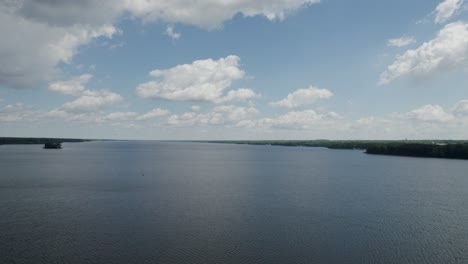 Toma-Aérea-Del-Lago-Con-Un-Magnífico-Cielo-Azul