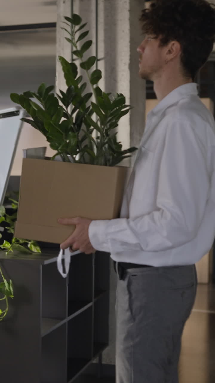 hombre saliendo de la oficina con una caja de cartón