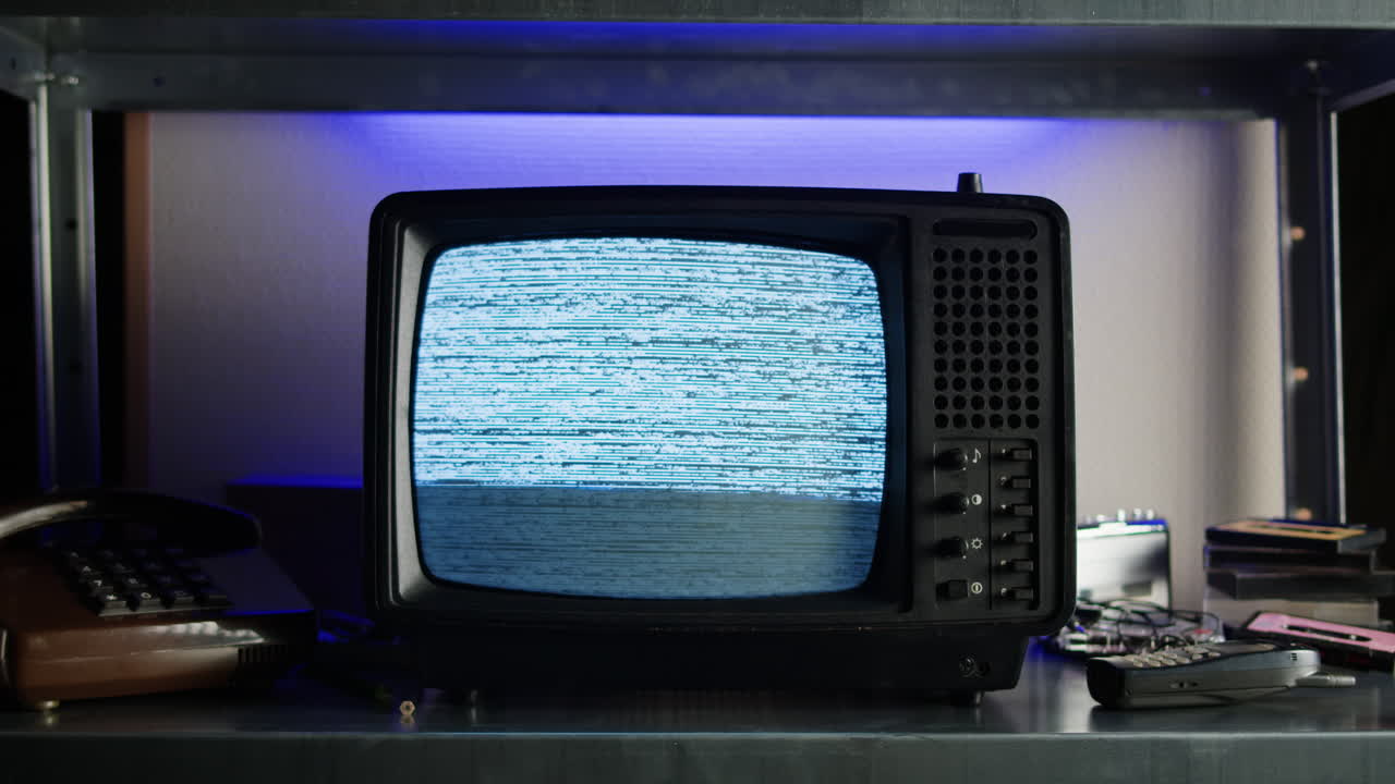 Retro TV, vintage television In a nostalgic setup, a retro TV displays grain on screen, scary halloween night device good for chroma key and green screen.