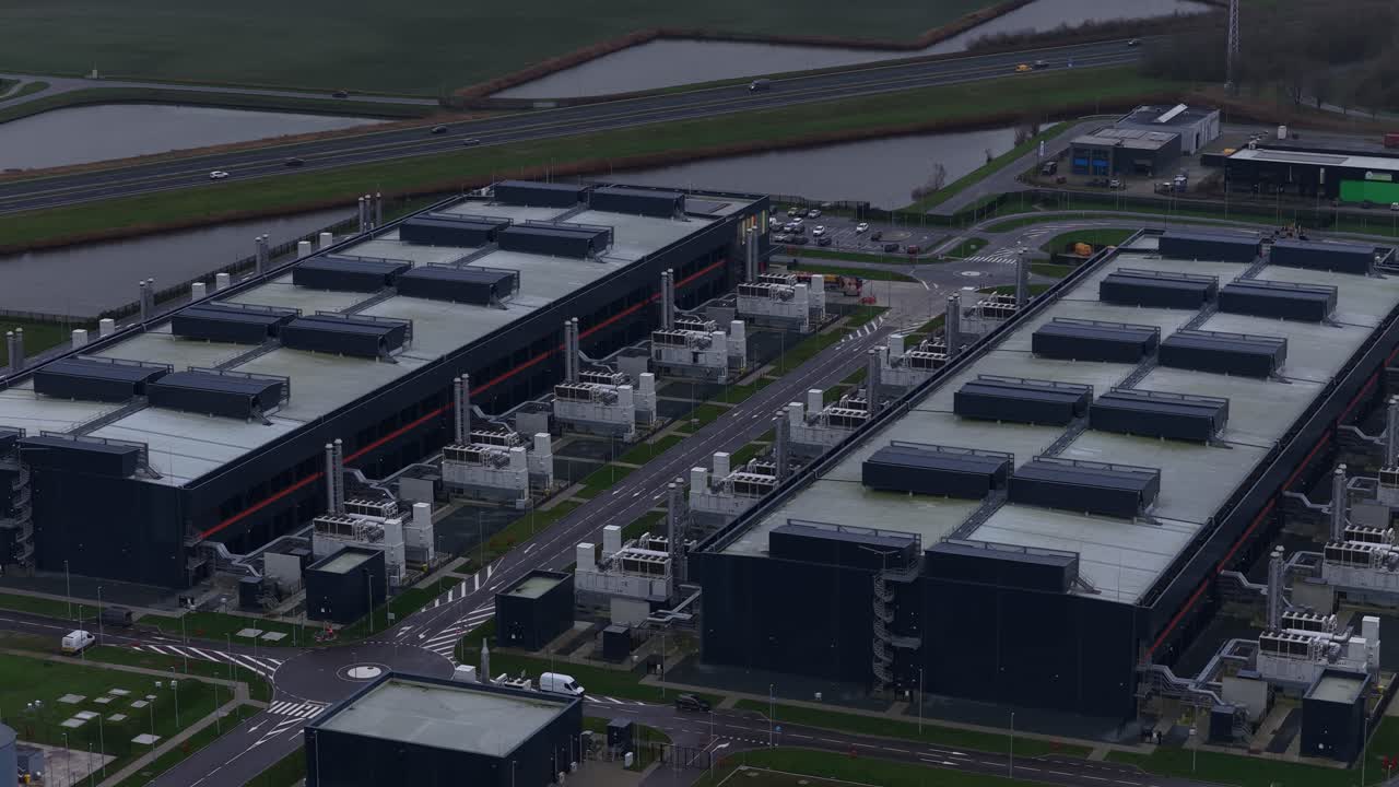 Aerial drone video of a large redundant colocation data center in Middenmeer, The Netherlands, showcasing massive data processing, storage capacity, and advanced AI computing infrastructure