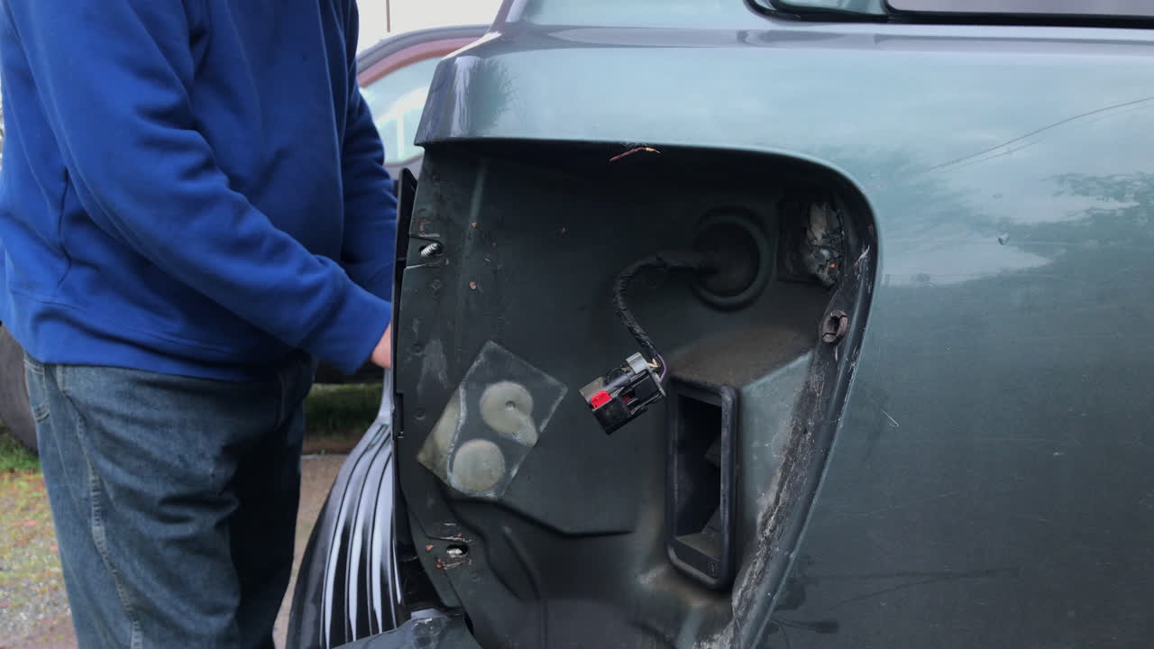 차 야외에 후미등을 고정하는 남자 - 핸드헬드, 미디엄 샷