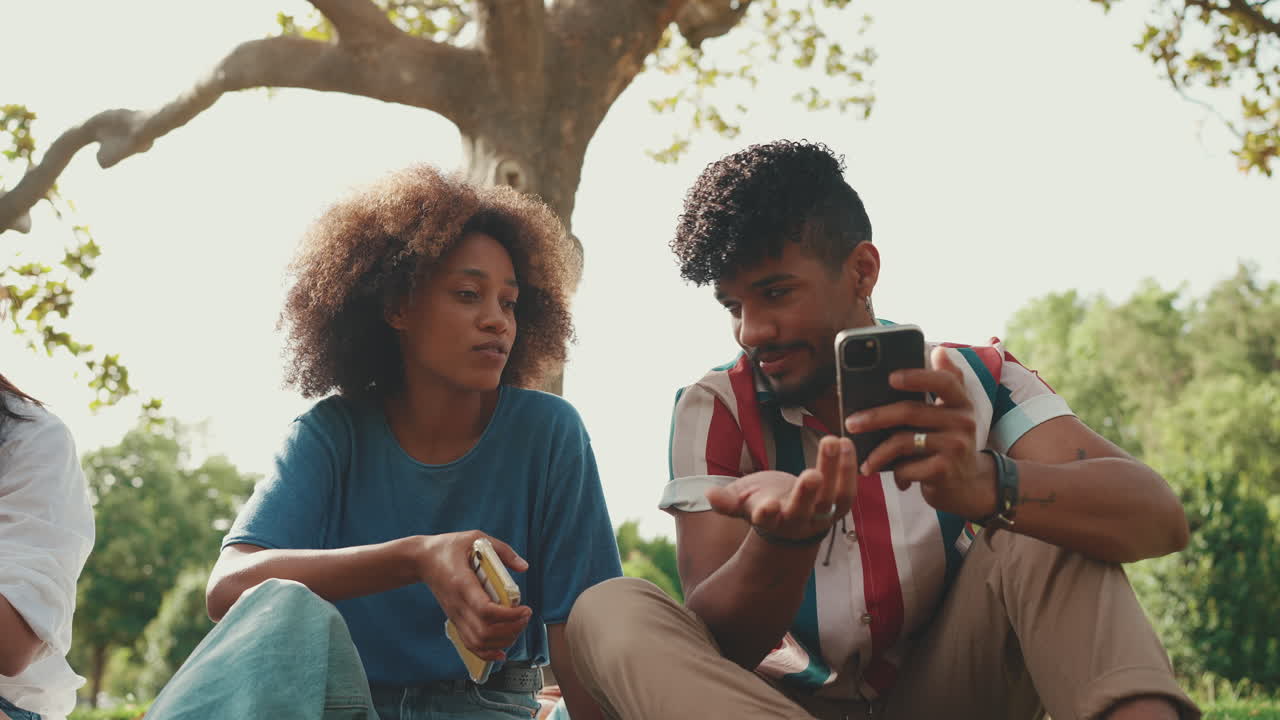 People sitting outside using phones