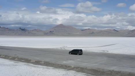 Coche-Aparcado-En-La-Carretera-Con-Fondo-Paisajístico-De-Salinas-épicas,-órbita-Aérea