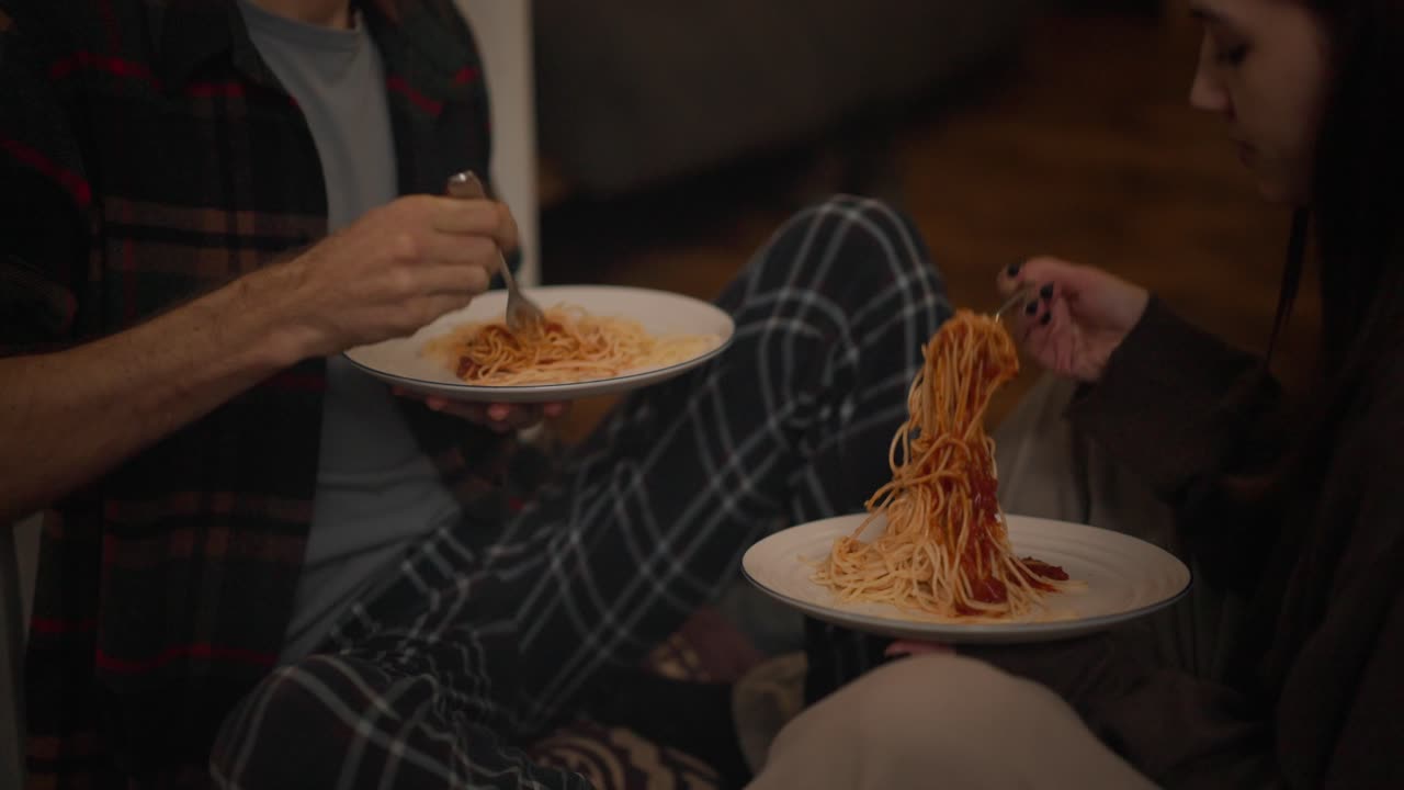 A couple eating pasta indoors