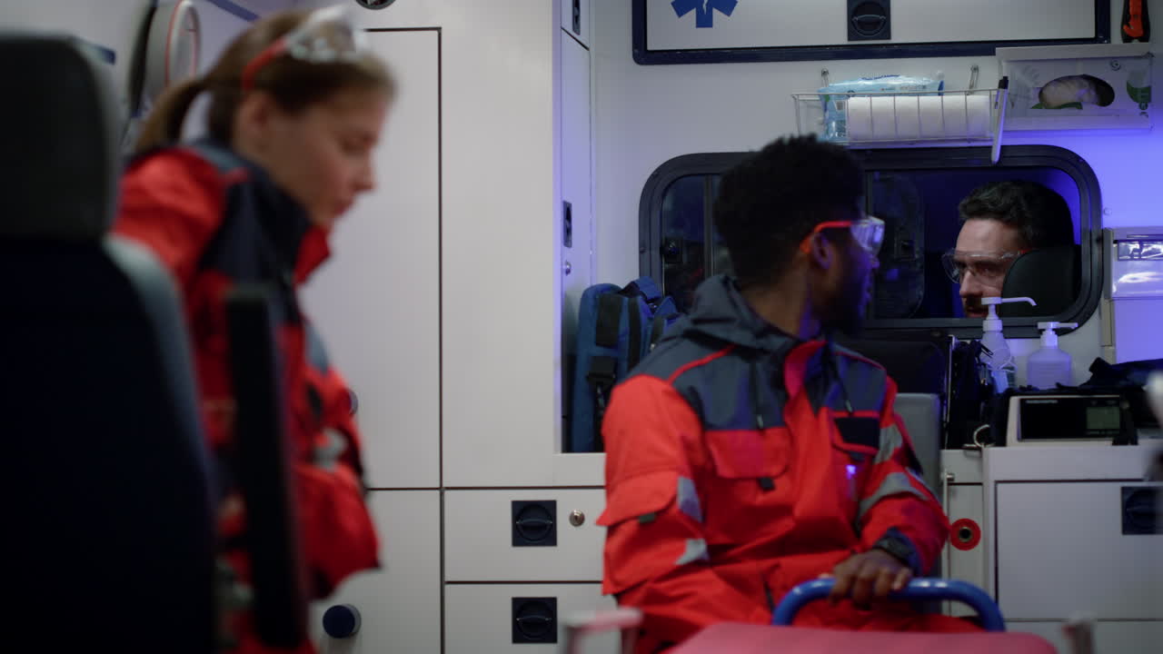 응급차에 타고 가는 구급대원 들. 의사 가 운전자 와 대화 하고 있다