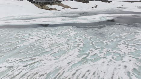 Vista-Aérea-De-Drones-Inclinados-Hacia-Arriba-Del-Hotel-Grimsel-Passhohe-En-Totensee-O-Lago-Totesee-En-El-Paso-De-Montaña-Grimsel-En-Suiza