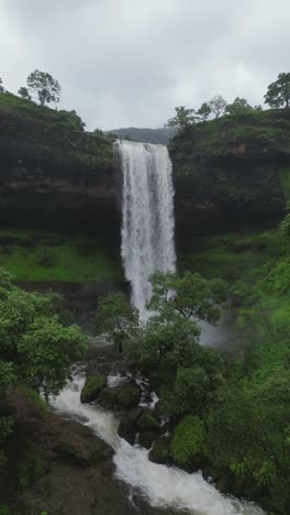 a breathtaking aerial view of stunning waterfalls cascading through the lush green forests of bhandardhara, maharashtra, india, water crashes over rugged cliffs creating a mesmerizing natural paradise