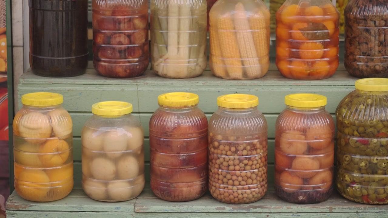 Surtido de frutas y verduras encurtidas y en conserva en frascos expuestos