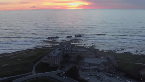 aerial: hotel by the sea at sunset, drone view