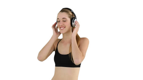 modelo en forma escuchando música y sonriendo