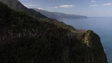 Drone-shot-moving-upwards-and-revealing-the-epic-landscape-with-a-young-and-fit-man-standing-alone-on-the-edge