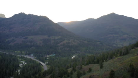 scenic mountain valley with forest and river at sunset or sunrise