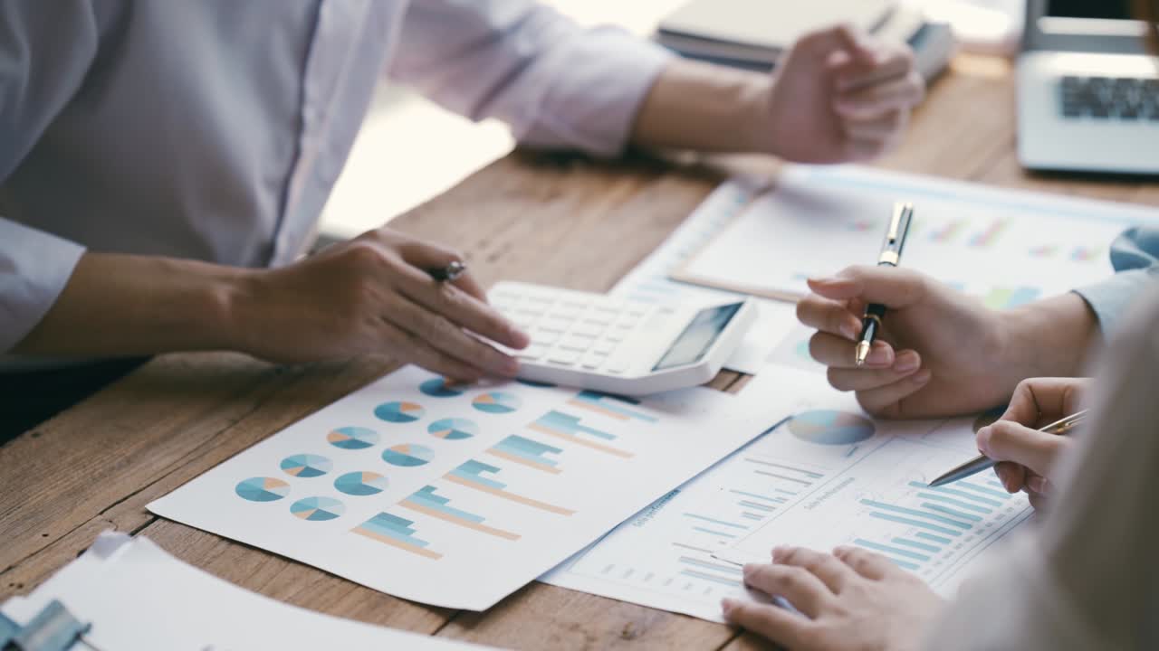 Business professionals working together at office desk, hands close up pointing out financial data on a report, teamwork concept. financial and investment.